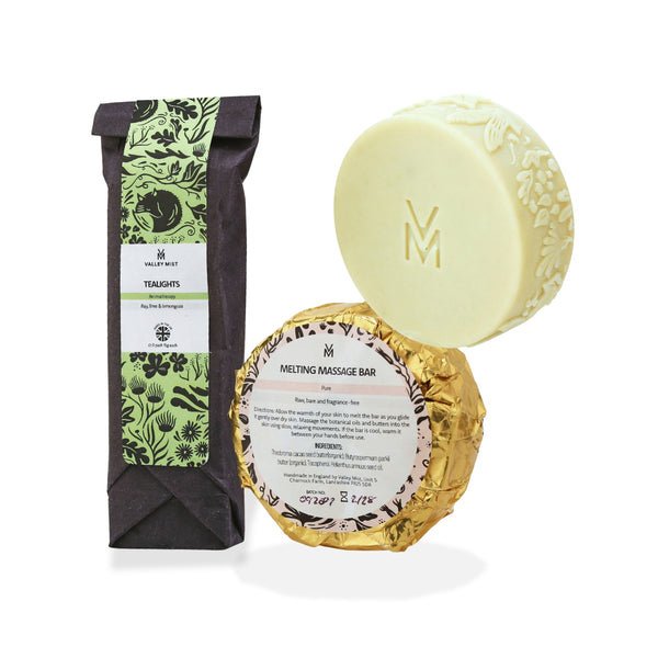 Valley Mist handmade Melting Massage Bar in two types, and tealight pack of candles. Showing the gold foil wrapped bar of the unfragranced Pure variant in the pale yellow solid bar with an embossed 'VM' logo