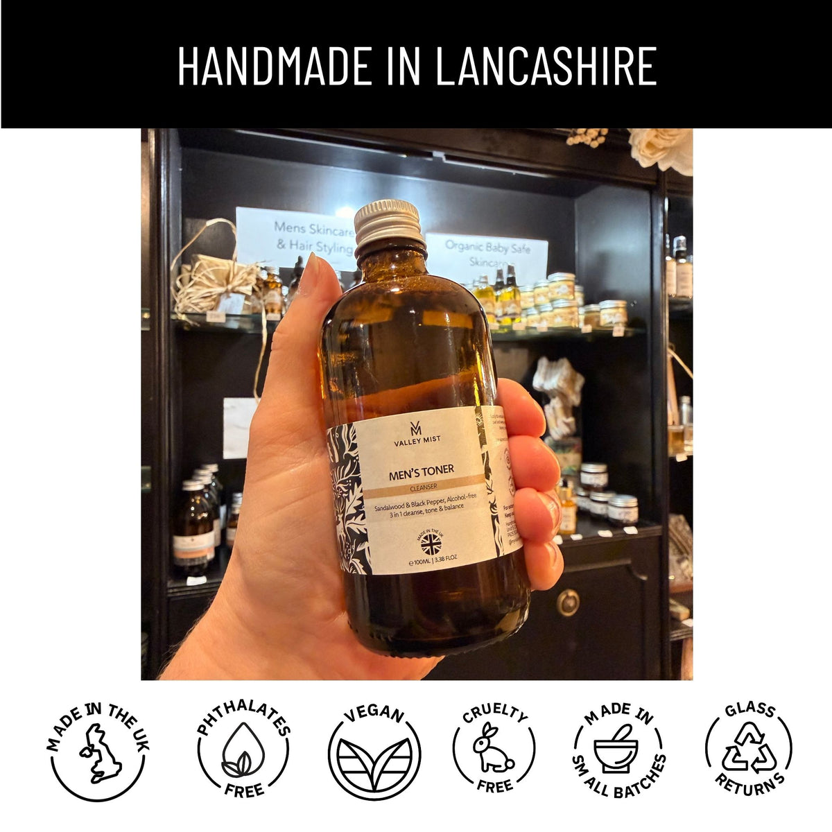 hand held for size 100 ml glass bottle toner with black shelves in the our of focus in the background with handmade in Lancashire banner at the top of the image